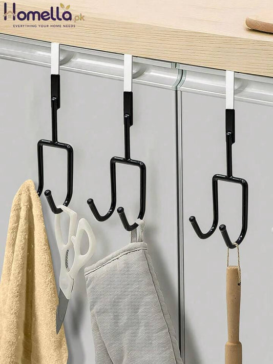 Black hooks on a white door with various items hanging from them.