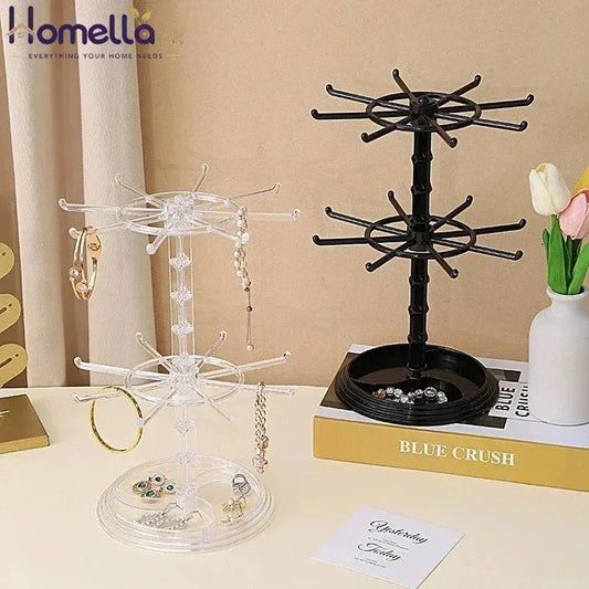 Two jewelry display stands on a table with books and a vase in the background.