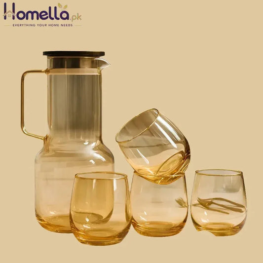 Set of amber glassware including a carafe and three glasses on a beige background