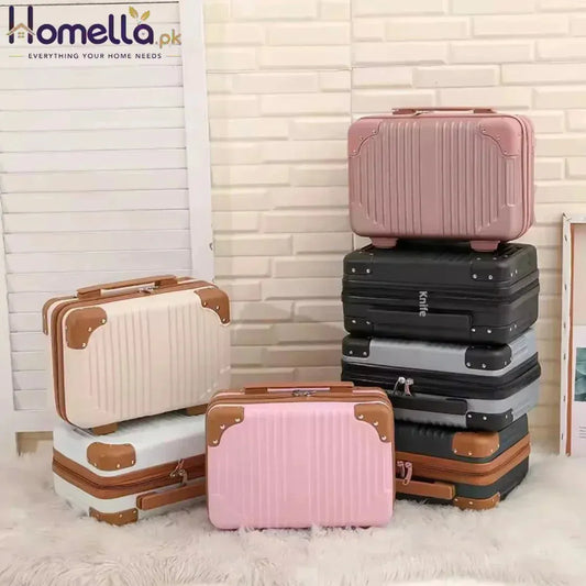 Set of suitcases in various colors stacked against a light-colored wall.