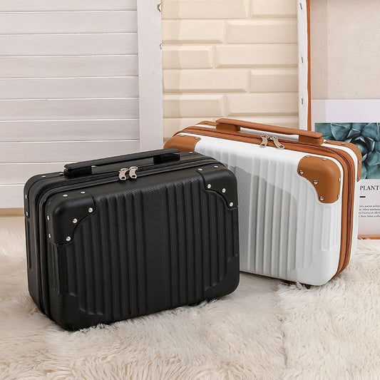 Black and white suitcases with brown handle on a light wooden floor.