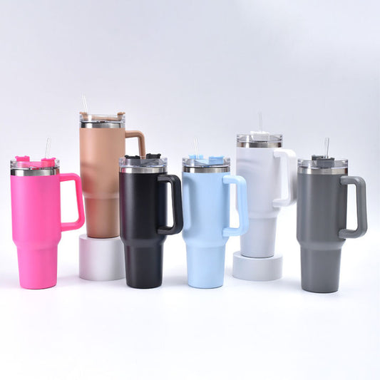 Set of insulated travel mugs with handles in various colors on a light gray background