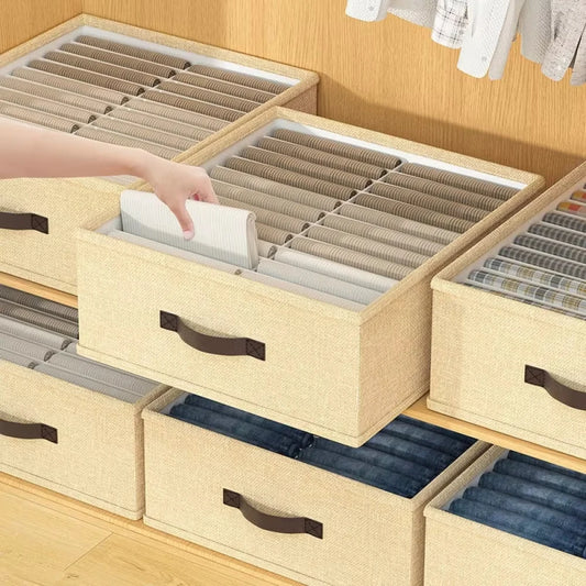 Stack of beige storage drawers with brown handles on a wooden floor.
