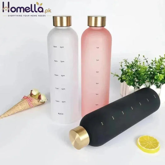 Three water bottles with gold caps on a white surface with decorative items.