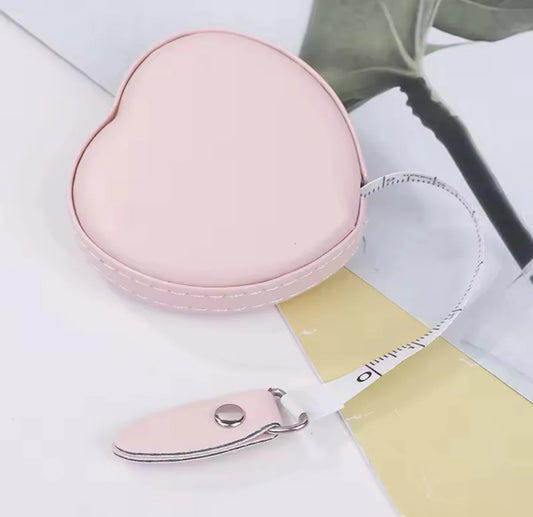 Pink heart-shaped case with a matching nail clipper on a light background