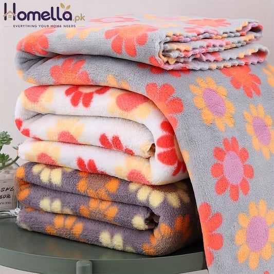 Stack of floral-patterned blankets on a green surface
